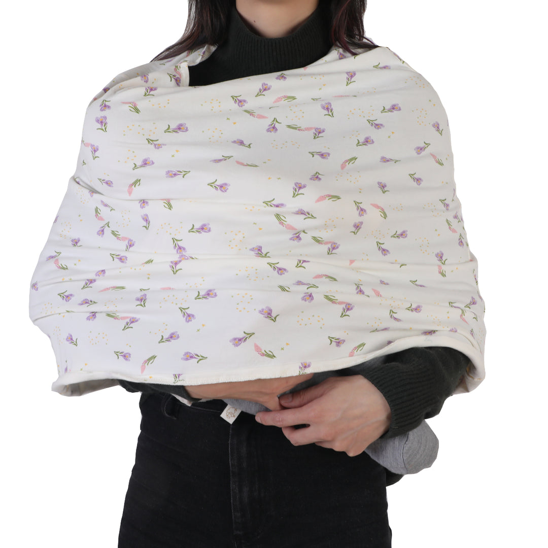 Floral-patterned baby wrap being held by a person on a white background